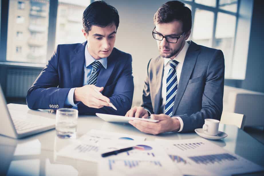 Two Men Looking Over Graphs